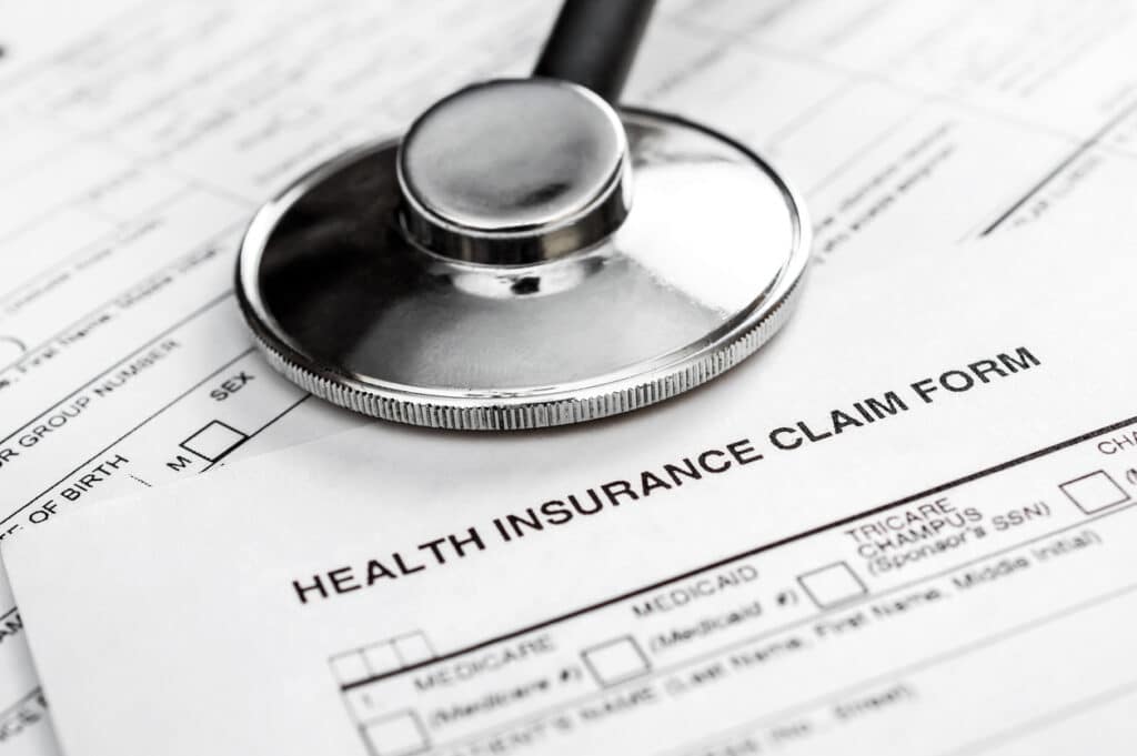 auto adjudication of healthcare claims; stethoscope on health insurance claim form